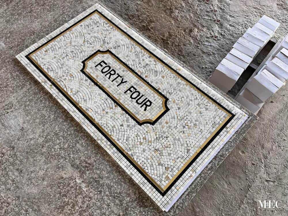 Typographic marble mosaic entrance floor plaque completed piece MEC workshop